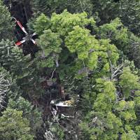 All nine crew members of this helicopter, which crashed Friday in Nakanojo, Gunma Prefecture, were confirmed dead Saturday. In this photo taken Friday afternoon, damaged trees at the crash site can be seen. | KYODO