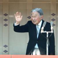 Emperor Akihito waves to the crowd gathered at the Imperial Palace in Tokyo to celebrate his 84th birthday on Dec. 23, 2017, as Crown Prince Naruhito looks on. | KYODO