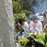 Women offer prayers Sunday to the victims of the 1985 Japan Airlines jumbo jet crash that claimed the lives of 520 people at Osutaka Ridge in Gunma Prefecture. | KYODO
