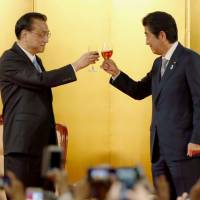 Prime Minister Shinzo Abe and Chinese Premier Li Keqiang make a toast at a welcome reception in Tokyo on May 10. | KYODO