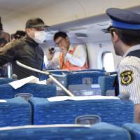 A security guard approaches a man playing the role of a knife-wielding perpetrator with a two-pronged weapon on Wednesday during a drill conducted by Central Japan Railway Co. (JR Tokai) on a bullet train at a stockyard in Mishima, Shizuoka Prefecture. | KYODO
