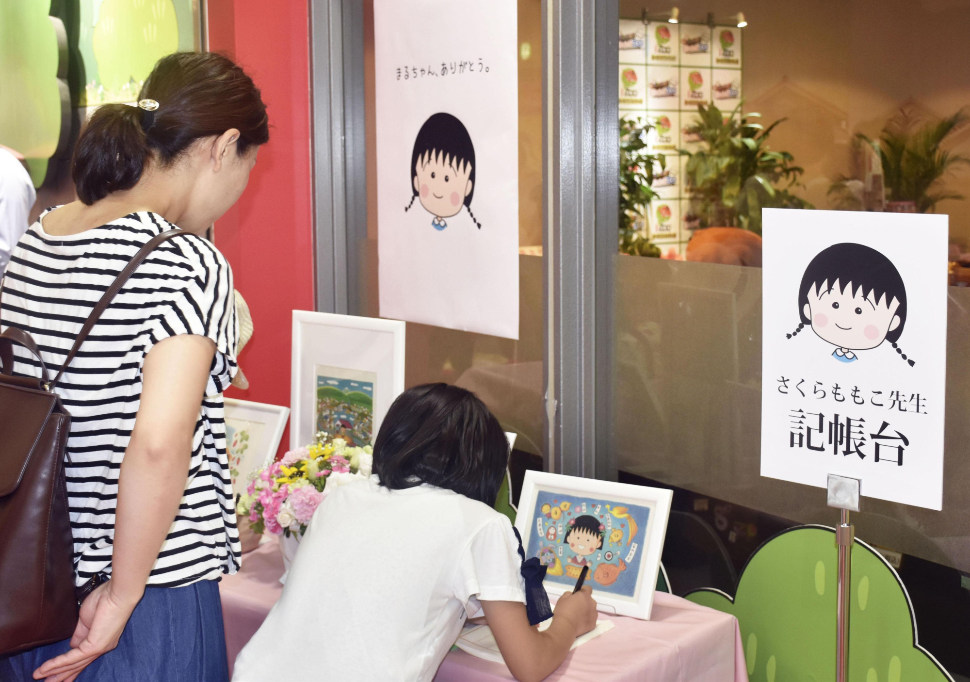 People sign a condolence book for Momoko Sakura, creator of the 'Chibi Maruko-chan' manga and anime series, at Chibi Maruko-chan Land in Shizuoka City on Tuesday. | KYODO