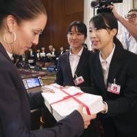 High school student peace ambassadors give signed petitions calling for the abolition of nuclear weapons to an official of the secretariat of the Conference on Disarmament on Tuesday in Geneva. | KYODO