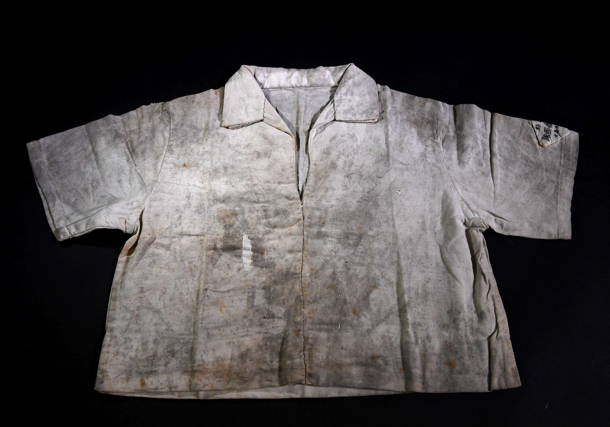 A shirt donated by Toyoko Matsumiya in 2012 to the Hiroshima Peace Memorial Museum still shows stains from so-called black rain, containing radioactive fallout, that fell on Aug. 6, 1945, after an atomic bomb destroyed the city. | CHUGOKU SHIMBUN