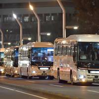 Long-distance night buses line up on a street in Tokyo\'s Shinjuku district in January. | KYODO