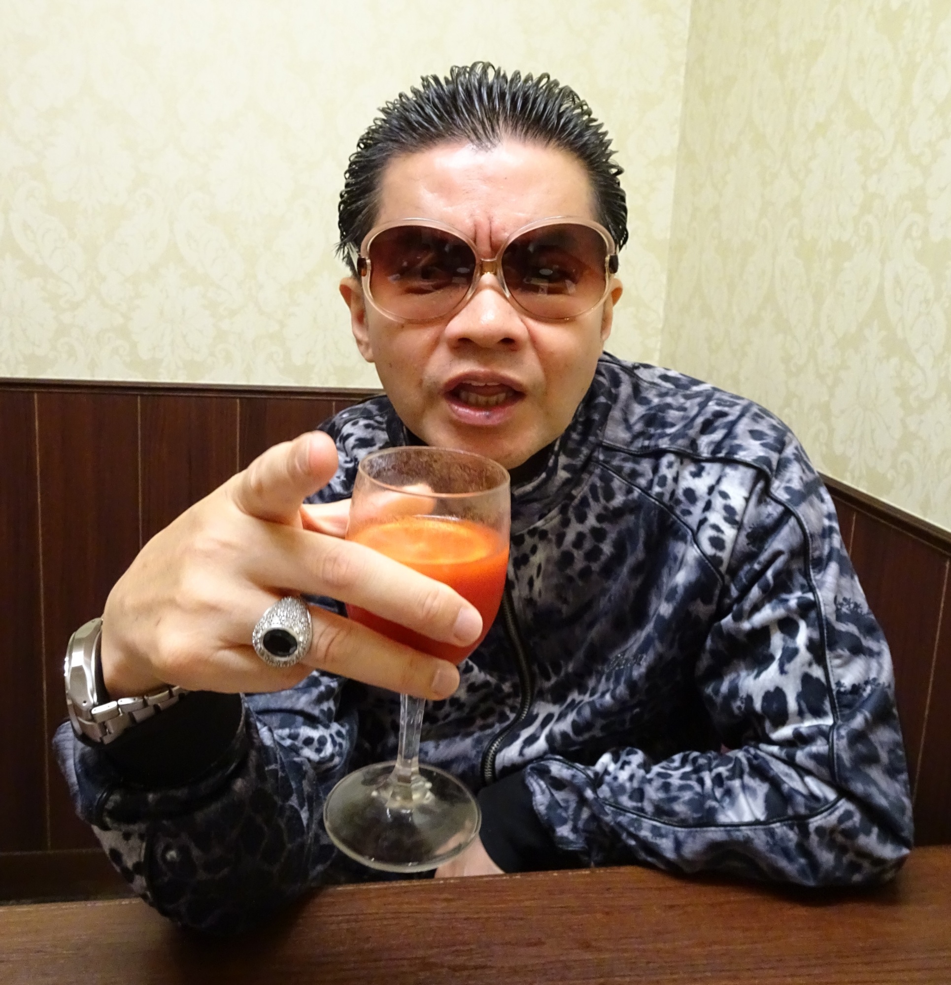 So Kuramoto, head of Takakura-gumi, scowls with a glass of tomato juice in hand at a cafe in Tokyo's Shinjuku Ward on Aug. 2. | ALEX MARTIN