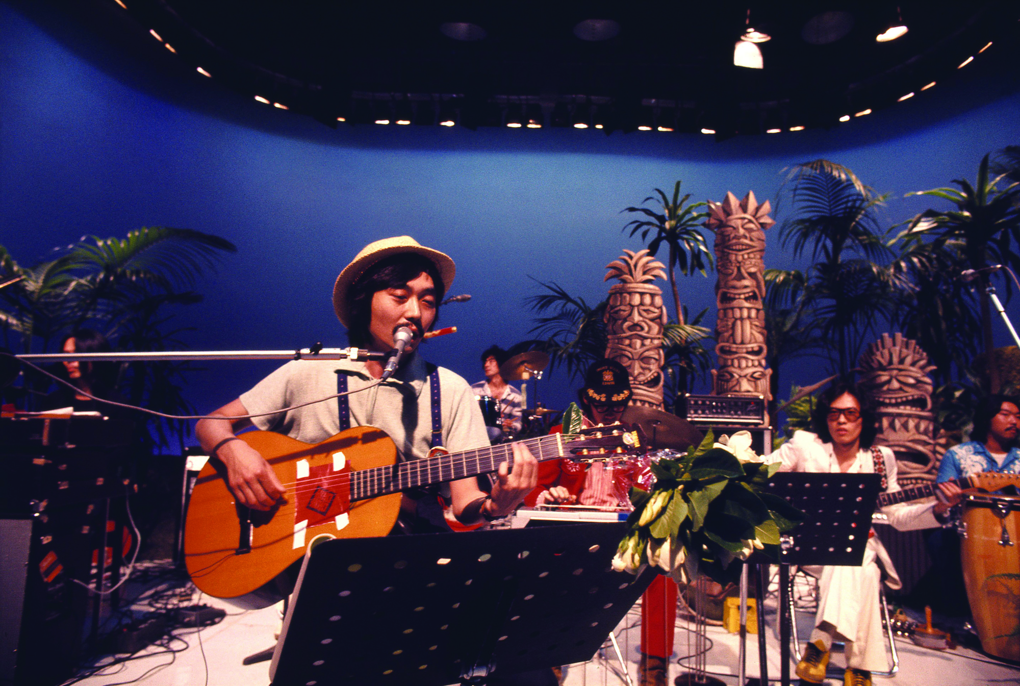 On screen: Haruomi Hosono takes part in a taping for the TV show 'Young Impulse' in July 1975. | COURTESY OF THE MASASHI KUWAMOTO ARCHIVES/ VIA LIGHT IN THE ATTIC