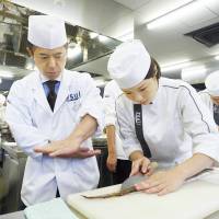 Hands on, scales off: A student learns to cut fish at theTsuji Culinary Institute. | COURTESY OF THE TSUJI CULINARY INSTITUTE