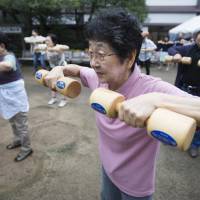 As old as you feel: A woman exercises at an event marking Respect for the Aged Day at a temple in Tokyo. This year the day falls on Sept. 17. | BLOOMBERG
