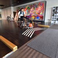 Wheelchair basketball player Masatsugu Shinoda approaches the Para Arena exit through a barrier-free aisle. In addition to wider entrances and exits, the facility boasts a large number of oversized parking spaces that are designed to accommodate wheelchair users. | YOSHIAKI MIURA