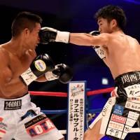 Ken Shiro (right) punches challenger Gilberto Pedrosa of Panama in a WBC light flyweight title match on Dec. 30, 2017, at Yokohama Cultural Gymnasium. | AFP-JIJI