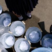 Towels soak in cool water at Koshien Stadium. | LANCE HENDERSTEIN