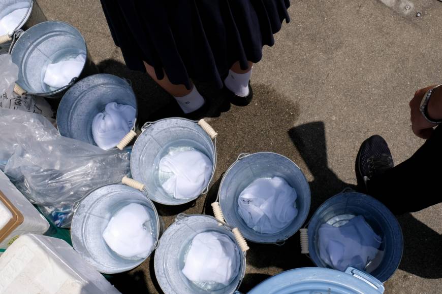 Towels soak in cool water at Koshien Stadium.