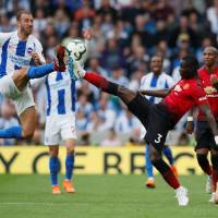 Manchester United\'s Eric Bailly (right) and Brighton\'s Glenn Murray vie for the ball during their match on Sunday in Brighton, England. Brighton won 3-2. | REUTERS