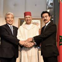 Moroccan Ambassador Rachad Bouhlal (center) poses for a photo with Japan-Morocco Parliamentary League President Hirofumi Nakasone (left) and Masahisa Sato, state minister for foreign affairs, during a reception to celebrate the 19th anniversary of King Mohammed VI\'s ascension to the throne at the Palace Hotel Tokyo on July 30. | YOSHIAKI MIURA