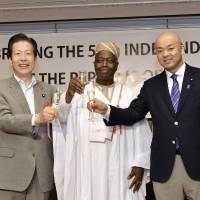 Beninese Ambassador Makarimi Abissola Adechoubou (center) poses for a photo with Komeito chief Natsuo Yamaguchi (left) and Parliamentary Vice-Minister for Foreign Affairs Manabu Horii during a reception to celebrate Benin\'s independence day at the Keio Plaza Hotel Tokyo on Aug. 1. | YOSHIAKI MIURA