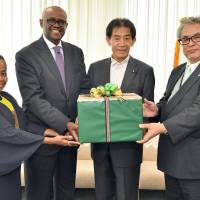 Kenyan Ambassador S.K. Maina (second from left) and First Secretary Khadija Issa (far left) pose for a photo with Ichiro Aisawa, chairman of the Japan-AU Parliamentary Friendship Association (third from left), and Nobuhisa Iida, secretary general of Japan Platform (far right), during a ceremony to give a donation of tea to those affected by the western Japan floods in Tokyo on Aug. 1. | YOSHIAKI MIURA