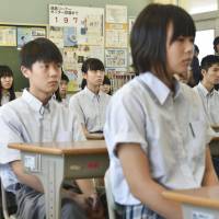 Kure senior high school students listen to a speech by the principal in a classroom Friday, as the public school becomes the first in Hiroshima Prefecture to open for the second semester after torrential rains swept across western Japan in early July. | KYODO