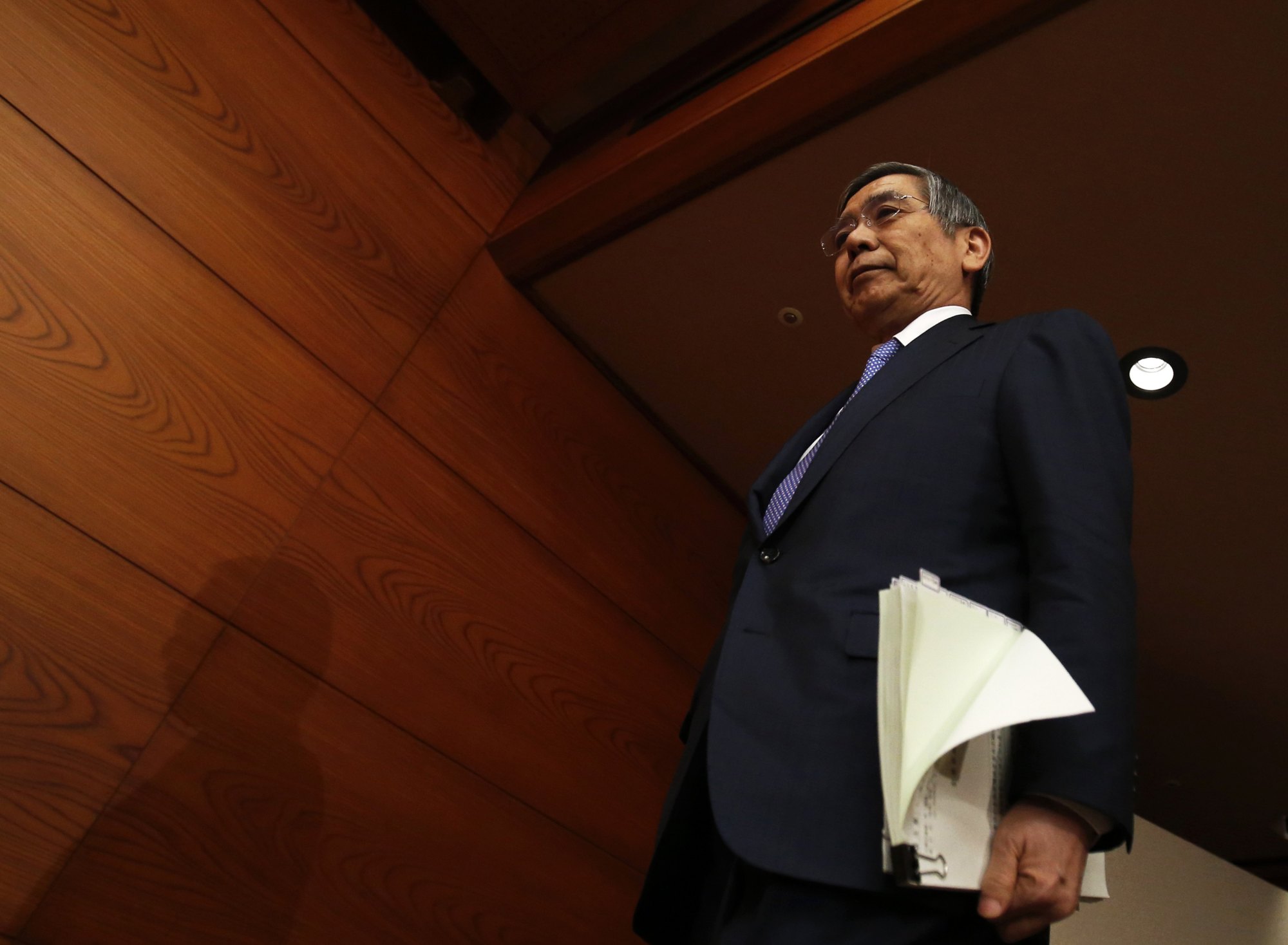 Bank of Japan Gov. Haruhiko Kuroda walks to a news conference at BOJ headquarters in Tokyo in March 2015. The minutes of the central bank policy board's September meeting showed some members called for more flexible monetary policies. | REUTERS