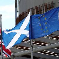 The Union Jack, Scottish Soltaire and European Union flags (from left) fly outside of the Scottish Parliament building in Edinburgh in 2016. | SCOTT HEPPELL / VIA REUTERS