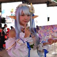 A cosplayer greets visitors at the Tokyo Game Show at Makuhari Messe in Chiba Prefecture on Thursday. | YOSHIAKI MIURA