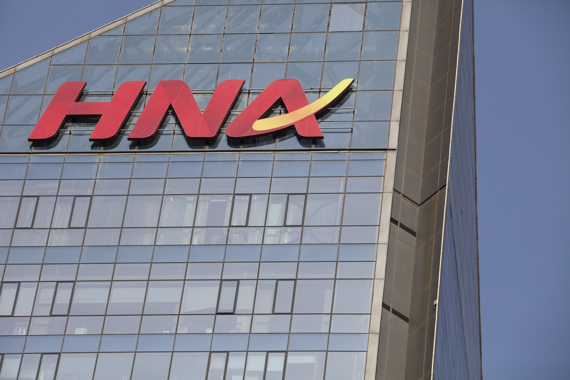 Signage for HNA Group Co. is displayed atop company premises in Beijing. | BLOOMBERG