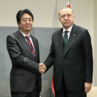 Prime Minister Shinzo Abe and Turkish President Recep Tayyip Erdogan get together for talks at the United Nations on Monday. | POOL / VIA KYODO