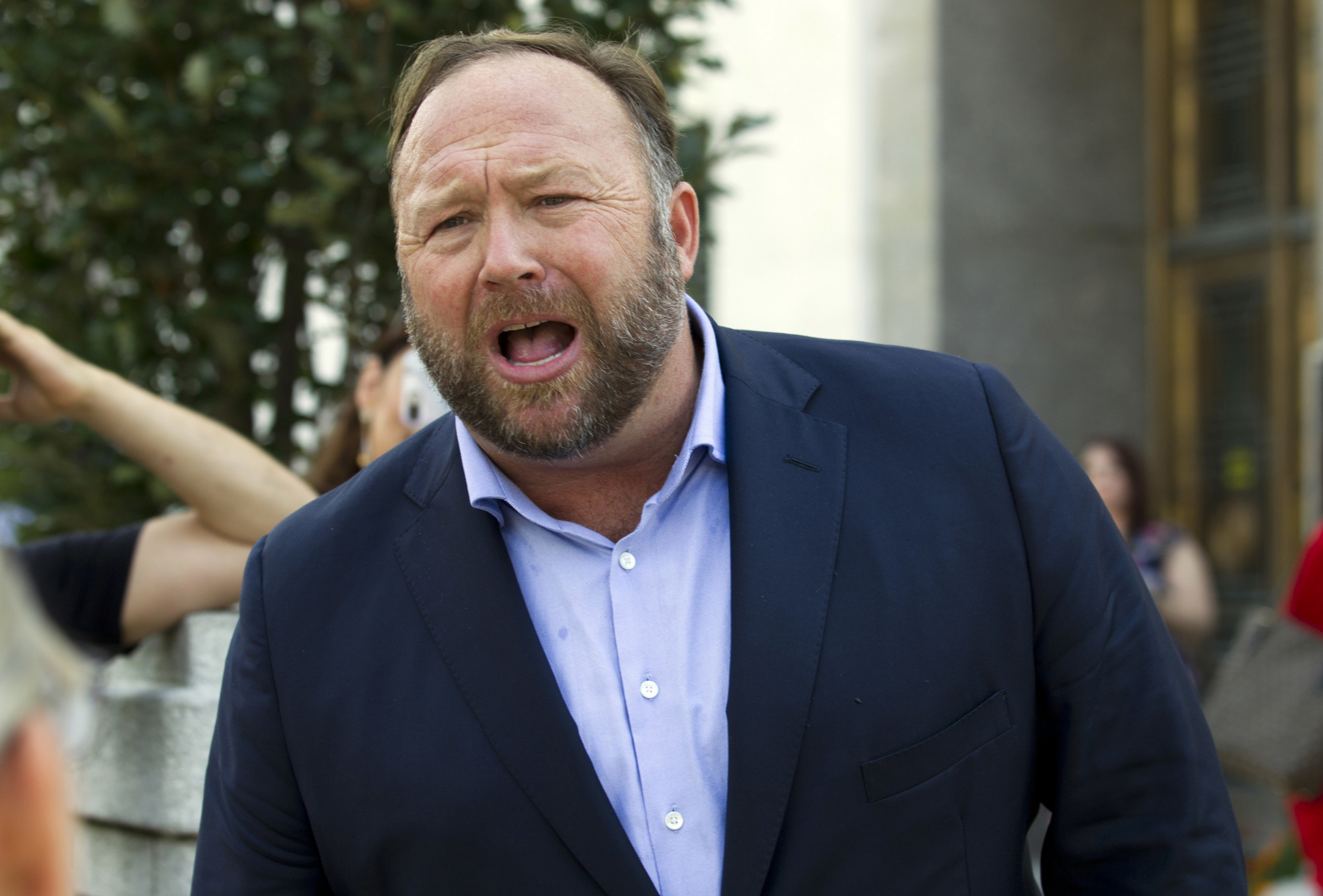 Conspiracy theorist Alex Jones speaks Wednesday outside of the Dirksen building of Capitol Hill after listening to Facebook COO Sheryl Sandberg and Twitter CEO Jack Dorsey testify before the Senate Intelligence Committee on 'Foreign Influence Operations and Their Use of Social Media Platforms' on Capitol Hill in Washington. Twitter is permanently banning right-wing conspiracy theorist Jones and his 'Infowars' show for abusive behavior. | AP