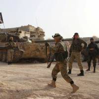 Members of al-Qaida\'s Nusra Front carry their weapons as they move toward their positions during an offensive to take control of the northwestern city of Ariha from forces loyal to Syria\'s President Bashar Assad, in Idlib province in 2015. | REUTERS