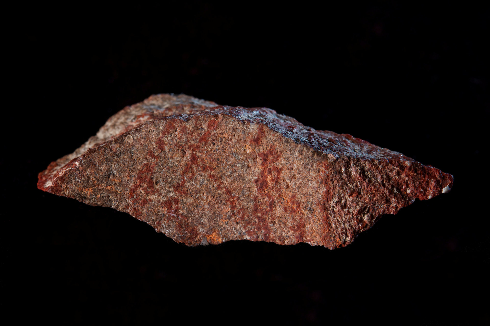 A stone flake discovered in Blombos Cave with red ochre markings that archeologists say represent one of the oldest-known examples of human drawings, on South Africa's southern coast, is shown in this photo released Wednesday. | CRAIG FOSTER / HANDOUT / VIA REUTERS