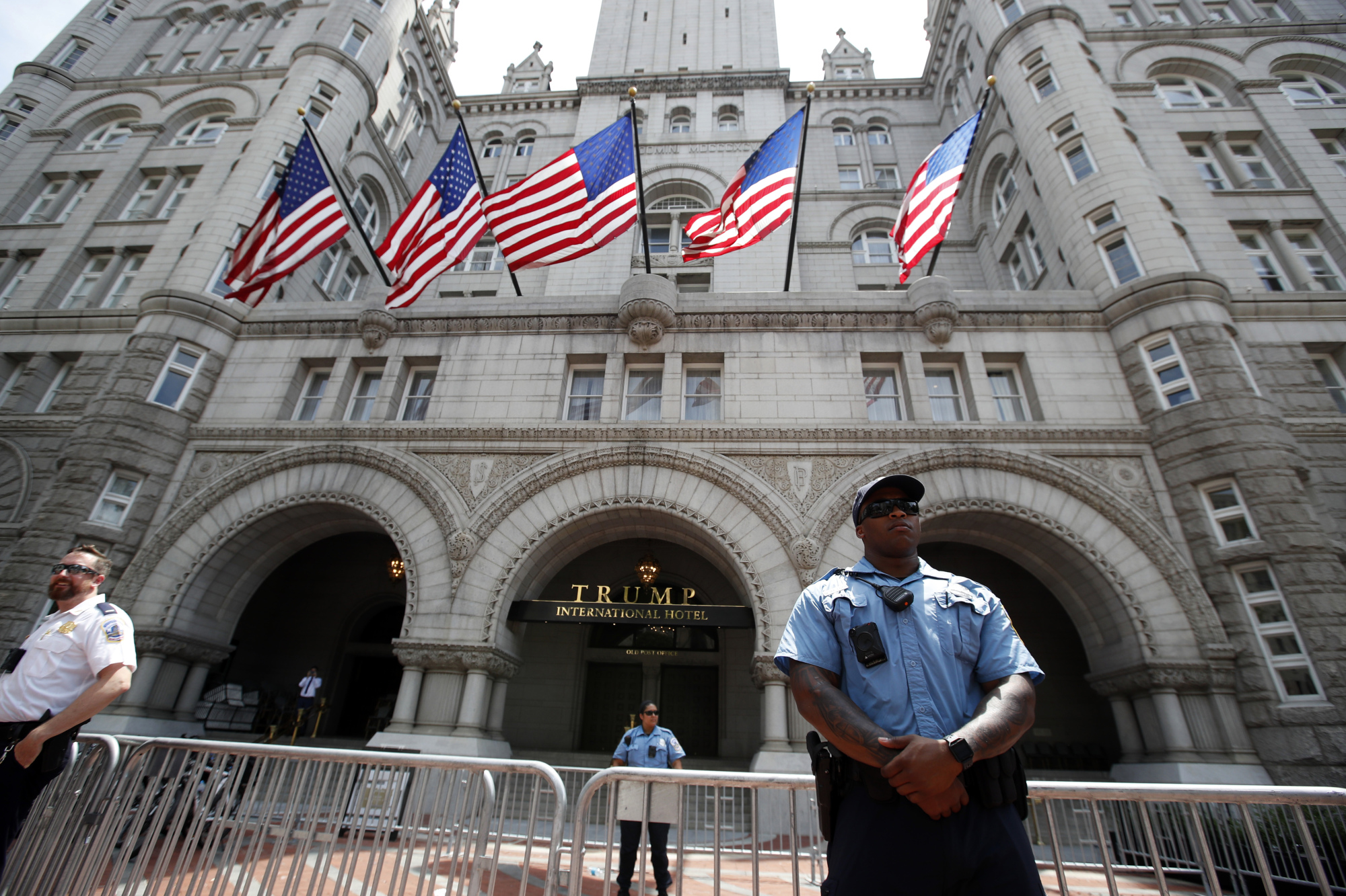 Law enforcement officers stand guard in front of the Trump Hotel in Washington in June. A federal district judge in Washington says a group of nearly 200 Democratic senators and representatives have legal standing to sue U.S. President Donald Trump to prove he violated the U.S. Constitution's emoluments provision. | AP