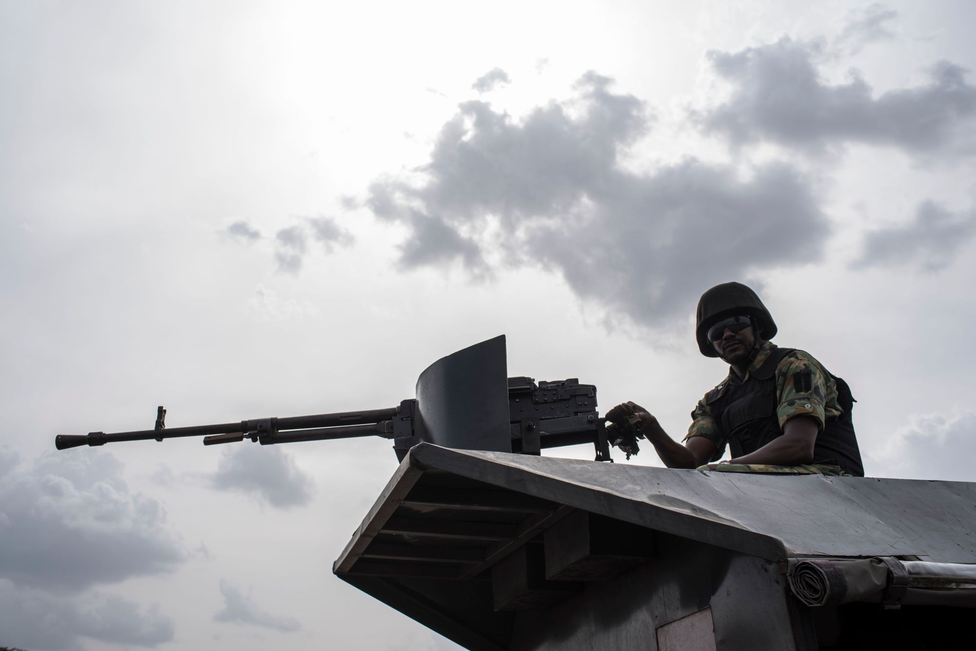 A member of the Nigerian Military Police sits on an armored vehicle during the African Land Forces Summit (ALFS) military demonstration held at General Ao Azazi barracks in Gwagwalada in April. At least 30 Nigerian soldiers died in combat with Boko Haram jihadists who overran a military base in the northeast near the border with Niger, two military sources told AFP on Saturday. Scores of jihadists in trucks stormed the base at Zari village in northern Borno state late Thursday and briefly seized it after a fierce battle, they said. | STEFAN HEUNIS / VIA AFP-JIJI