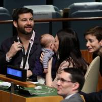 New Zealand Prime Minister Jacinda Ardern kisses her baby, Neve, before speaking at the Nelson Mandela Peace Summit during the 73rd United Nations General Assembly in New York Monday. | REUTERS