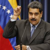 Venezuelan President Nicolas Maduro demonstrates his Salt Bae sprinkling technique during a press conference at the Miraflores Presidential Palace in Caracas Tuesday. | AP