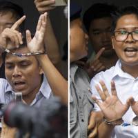 Reuters reporters Kyaw Soe Oo (left) and Wa Lone are escorted by police out of a court Monday in Yangon after their sentencing. | AP