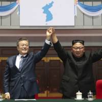 South Korean President Moon Jae-in and North Korean leader Kim Jong Un raise their hands after watching the mass games performance of \"The Glorious Country\" at May Day Stadium in Pyongyang on Wednesday. | AP