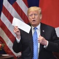 U.S. President Donald Trump shows a letter he said he received the previous day from North Korean leader Kim Jong Un, during a bilateral meeting with Prime Minister Shinzo Abe on Wednesday on the sidelines of the United Nations General Assembly in New York. | AFP-JIJI