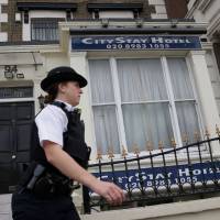 A police officer stands outside the City Stay Hotel, where Russian suspects Alexander Petrov and Ruslan Boshirov stayed, in Bow, east London, on Thursday. British detectives released Wednesday the painstakingly pieced together movements and methodology of two Russians suspected of trying to assassinate Sergei Skripal in a chemical weapon attack. After thousands of hours of work, they have traced the steps of Alexander Petrov and Ruslan Boshirov as they arrived in Britain on March 2, conducted a reconnaissance mission in Salisbury, carried out their attack on March 4 and immediately headed back to Russia. | AFP-JIJI