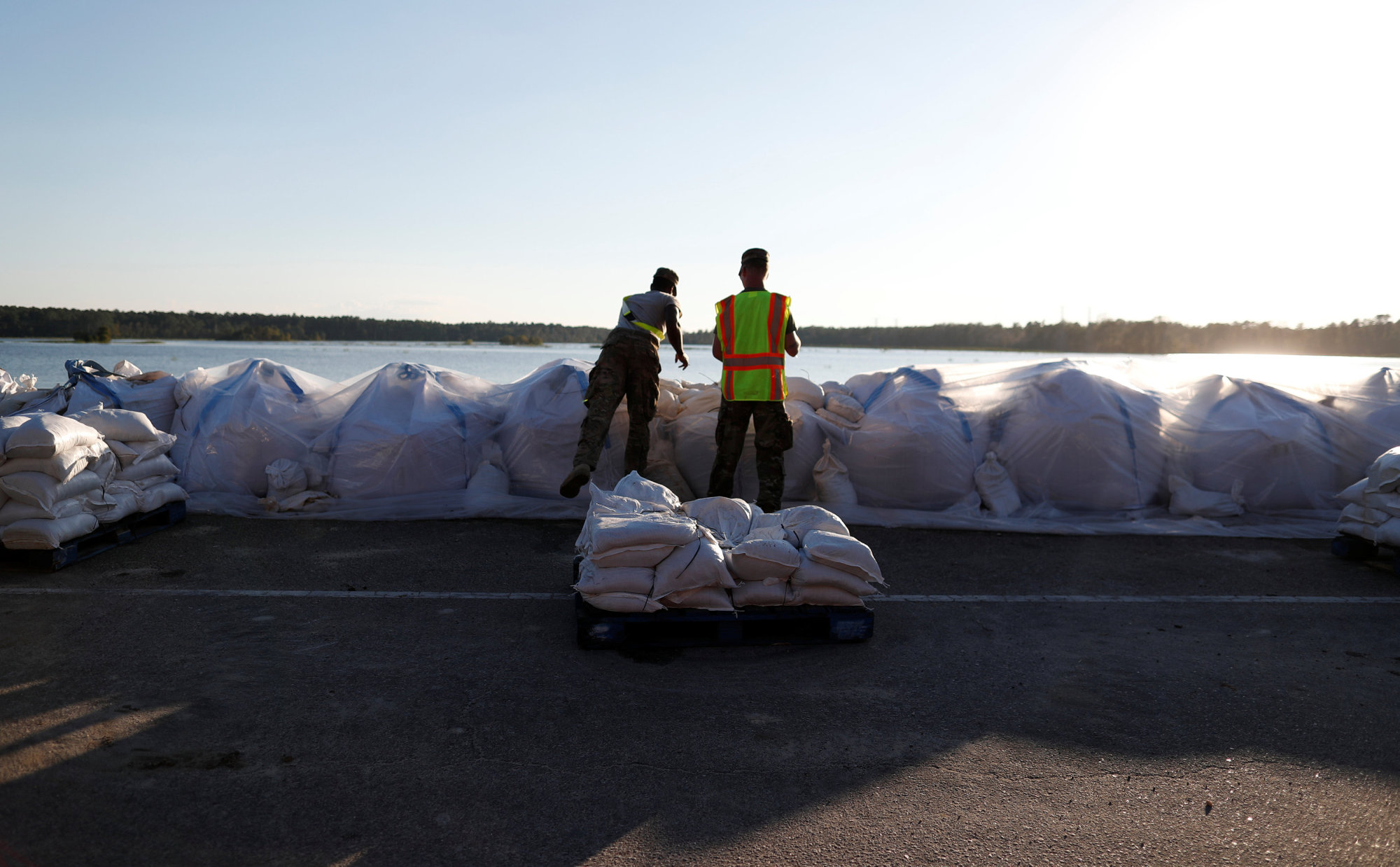 Members of the National Guard work on a long sand bag flood barrier being built by the South Carolina Department of Transportation on U.S. 501 to lesson damage to roads anticipated from floods caused by Hurricane Florence, now downgraded to a tropical depression, in Conway, South Carolina, Wednesday. | REUTERS