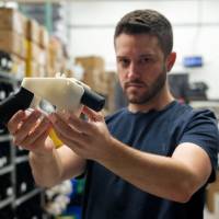 Cody Wilson, owner of Defense Distributed, holds a 3D printed gun, the \"Liberator,\" in his factory in Austin, Texas, on Aug. 1. | AFP-JIJI