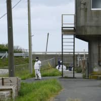 Police officers investigate in the area where a dismembered body was found Saturday morning in Oamishirasato, Chiba Prefecture. | KYODO