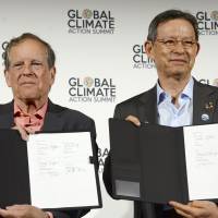 Takejiro Sueyoshi (right) of the Japan Climate Initiative and America\'s Pledge Vice Chairman Carl Pope sign a partnership in San Francisco on Thursday. | KYODO