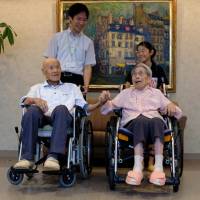 Masao Matsumoto (left) and Miyako Matsumoto, confirmed as the world\'s oldest living married couple by Guinness World Records, pose for a photo with a great-grandchild and care staff at a nursing house in Takamatsu, Kagawa Prefecture, on Tuesday. | REUTERS