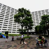 Residents make their way through the courtyard of giant public housing unit Shibazono Danchi in Kawaguchi, Saitama Prefecture, on Friday. The unit\'s demographic mainly consists of young, foreign families and elderly Japanese. | YOSHIAKI MIURA