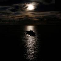 Japanese helicopter carrier the Kaga is silhouetted against the reflection of the sun on the ocean during a joint naval drill with the British frigate HMS Argyle and Japanese destroyer Inazuma in the Indian Ocean Wednesday. | REUTERS