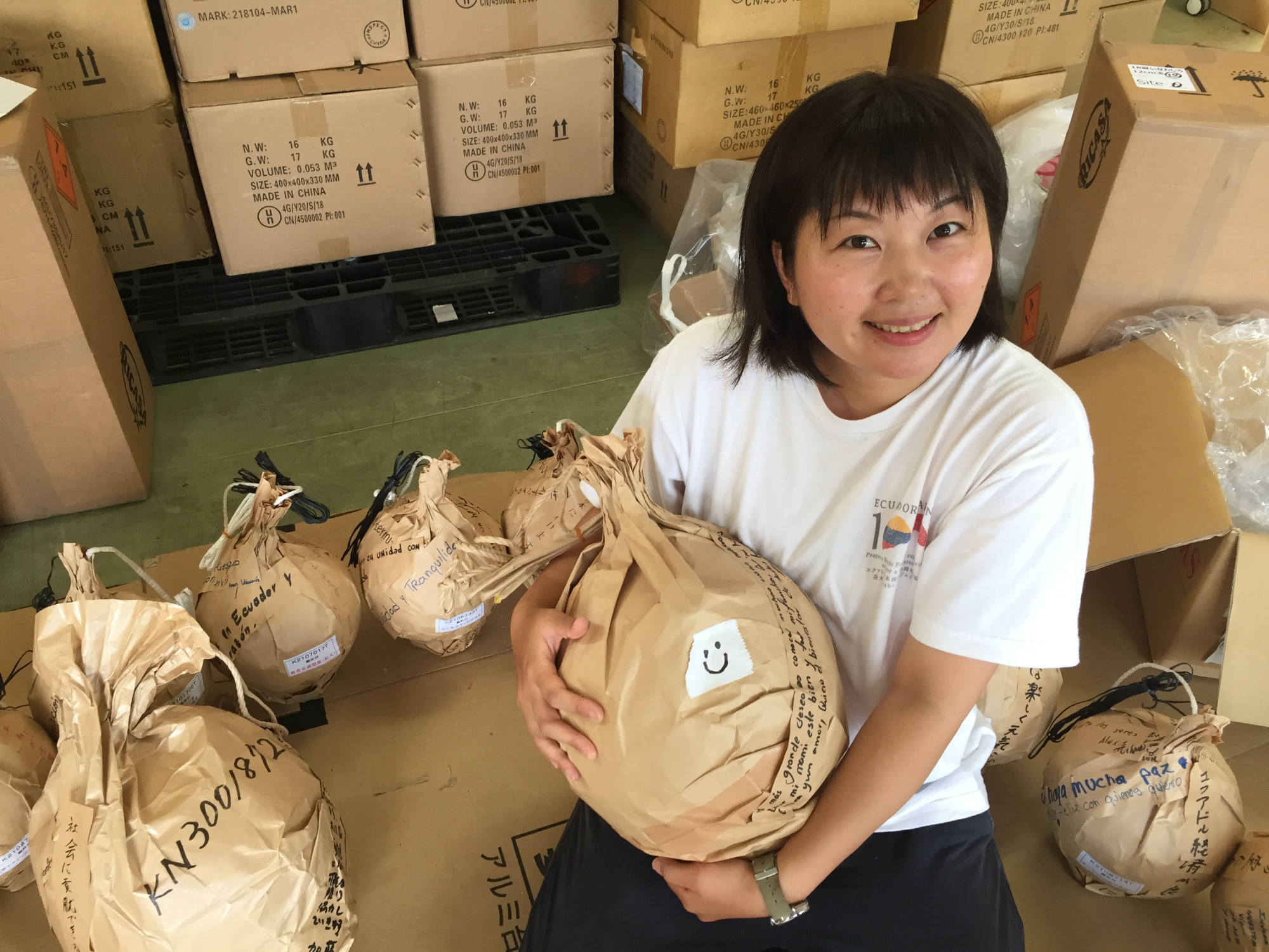 Ayumi Miyaura, who launched a fireworks show linking Ecuador to a Fukushima town in August, holds shell casings with wishes wrapped around them in this undated photo. | COURTESY OF AYUMI MIYAURA