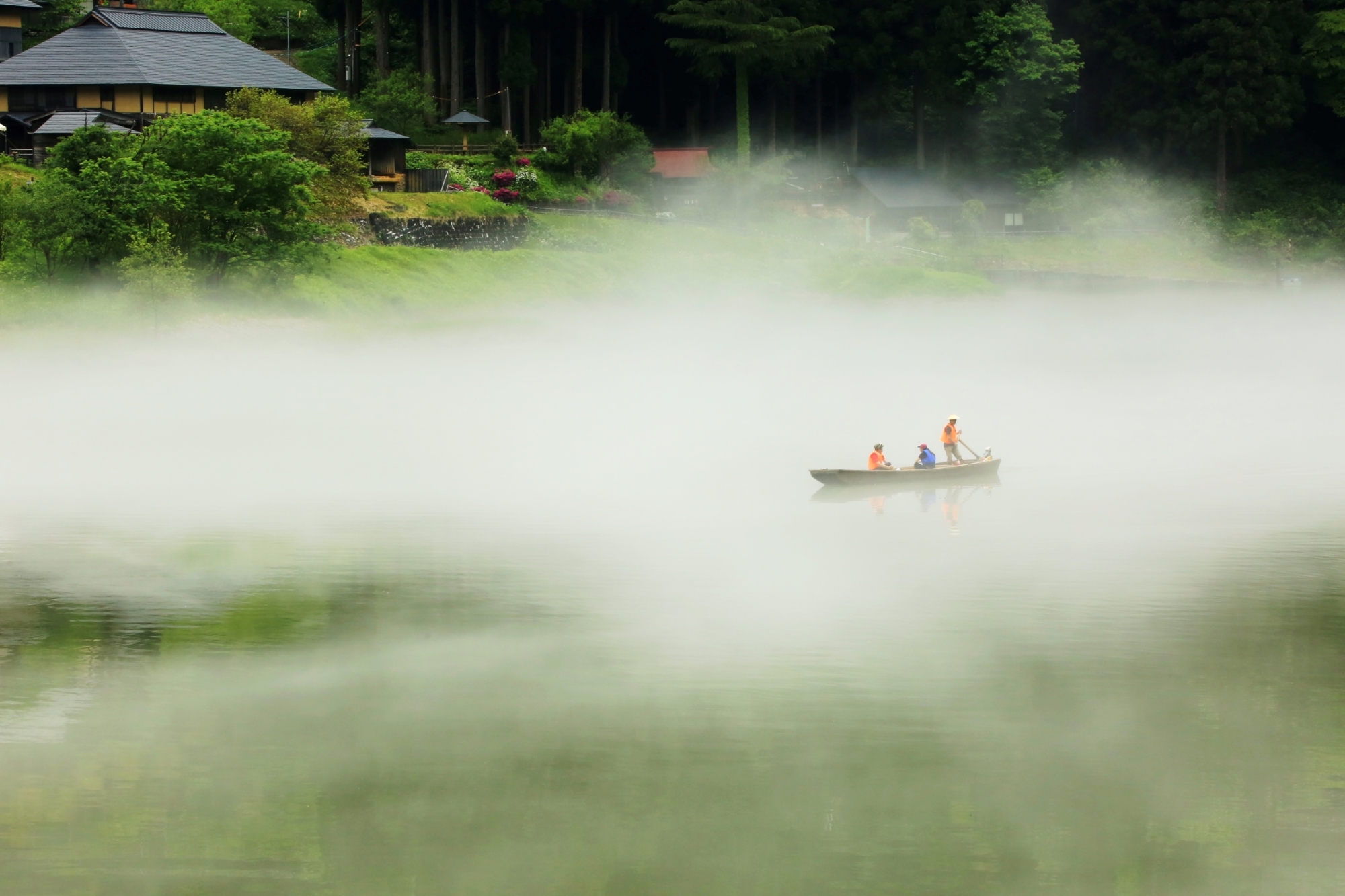 A rowboat passes through thick fog on the Tadami River in the town of Kaneyama, Fukushima Prefecture. The river tour has become popular with tourists from Japan and abroad. | FUKUSHIMA MINPO