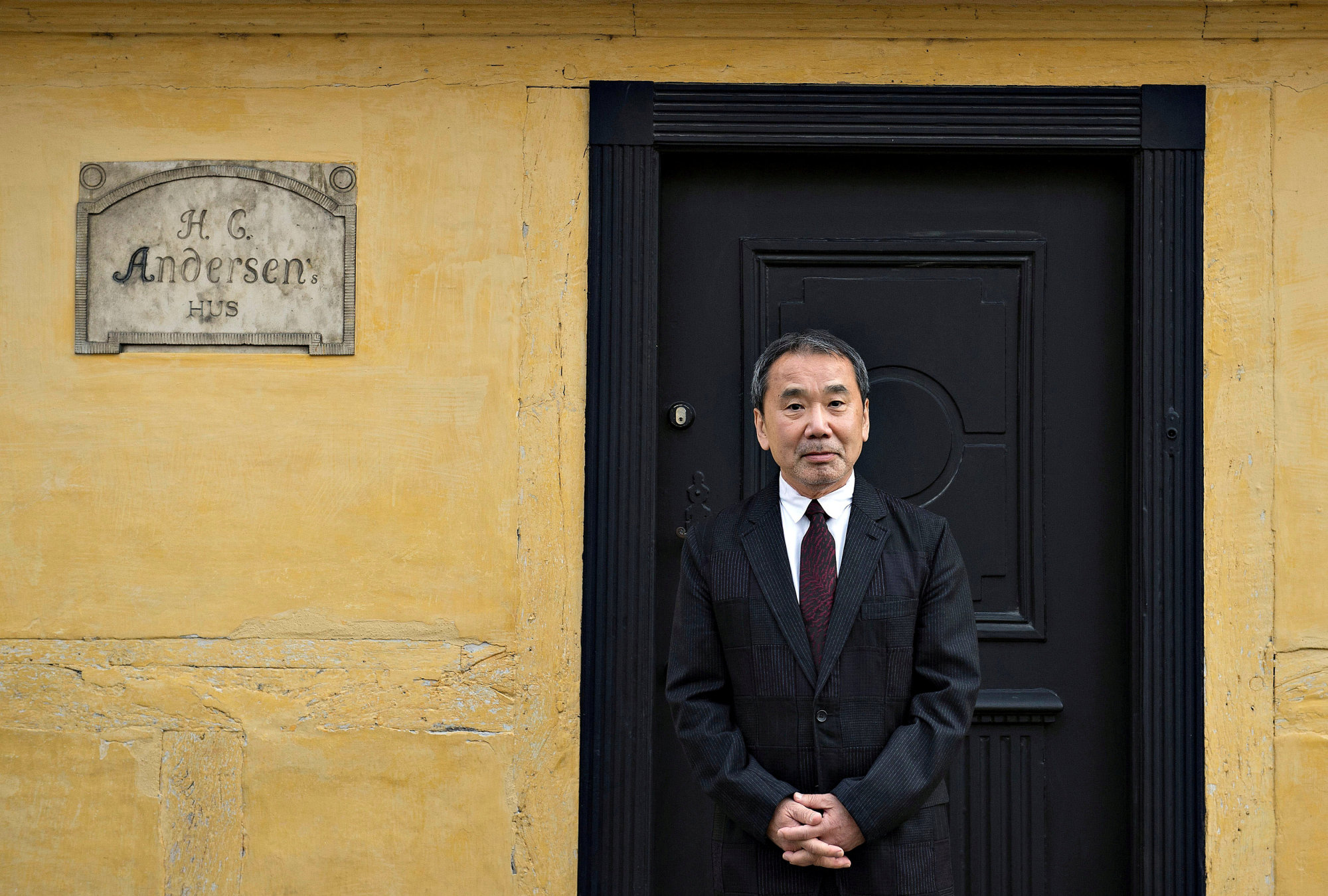 Japanese writer Haruki Murakami, winner of the 2016 Hans Christian Andersen Literature Award, is seen outside Andersen's house in Odense, Denmark, in October 2016. | REUTERS