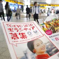 Leaflets soliciting volunteers for the 2020 Tokyo Olympics are distributed Wednesday near Shinjuku Station. | KYODO