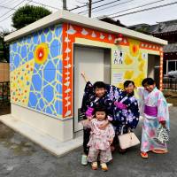Local children pose in front of a public lavatory that they helped paint in Asahi Park in Tokyo\'s Sugamo district on Sunday. | YOSHIAKI MIURA